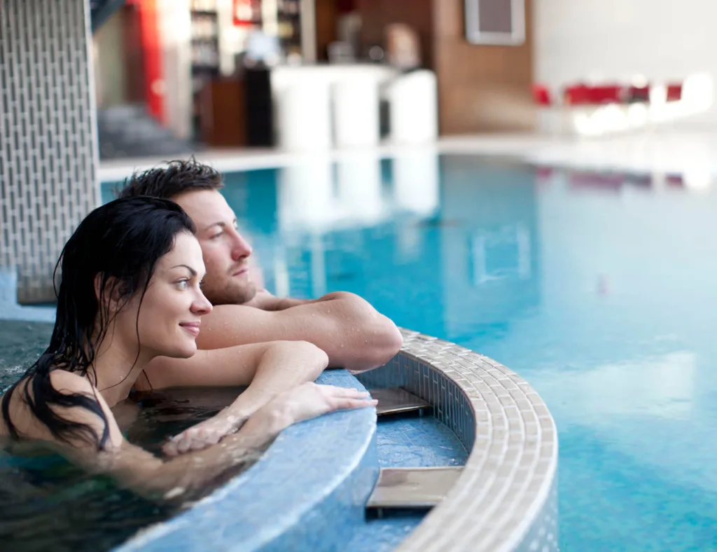 Couple Relaxing In Jacuzzi Of Spa Center